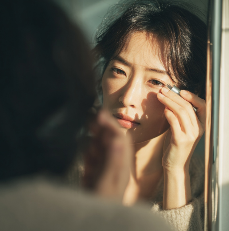 거울을 보며 인공눈물을 넣는 여성