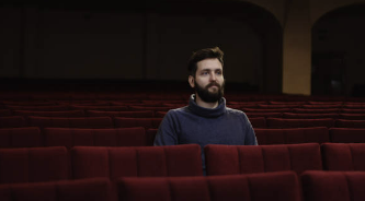 30대로 보이는 남성이 홀로 영화를 보고 있는 사진