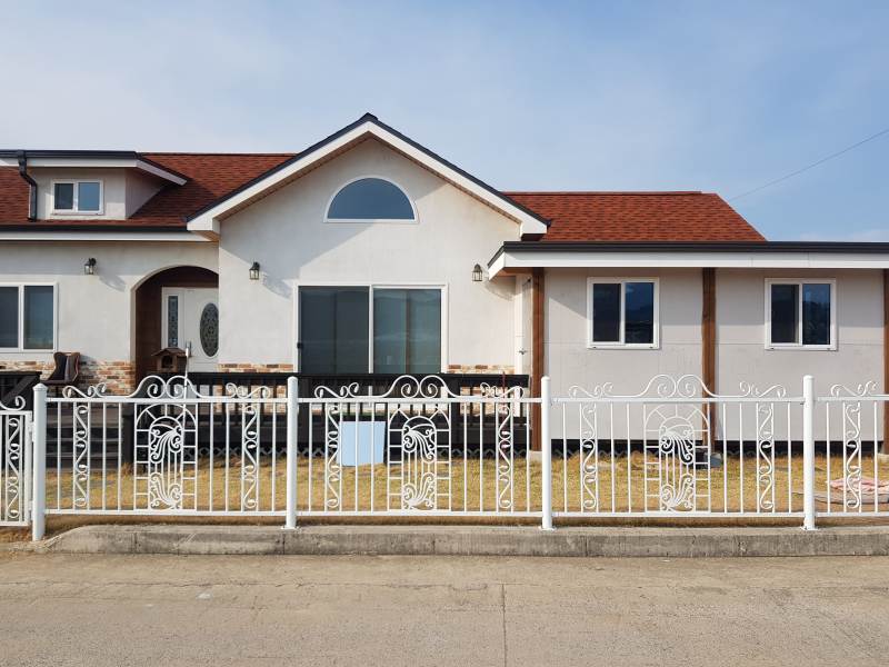 울타리-잔디-붉은 타일 지붕-하얀 벽-단층 주택