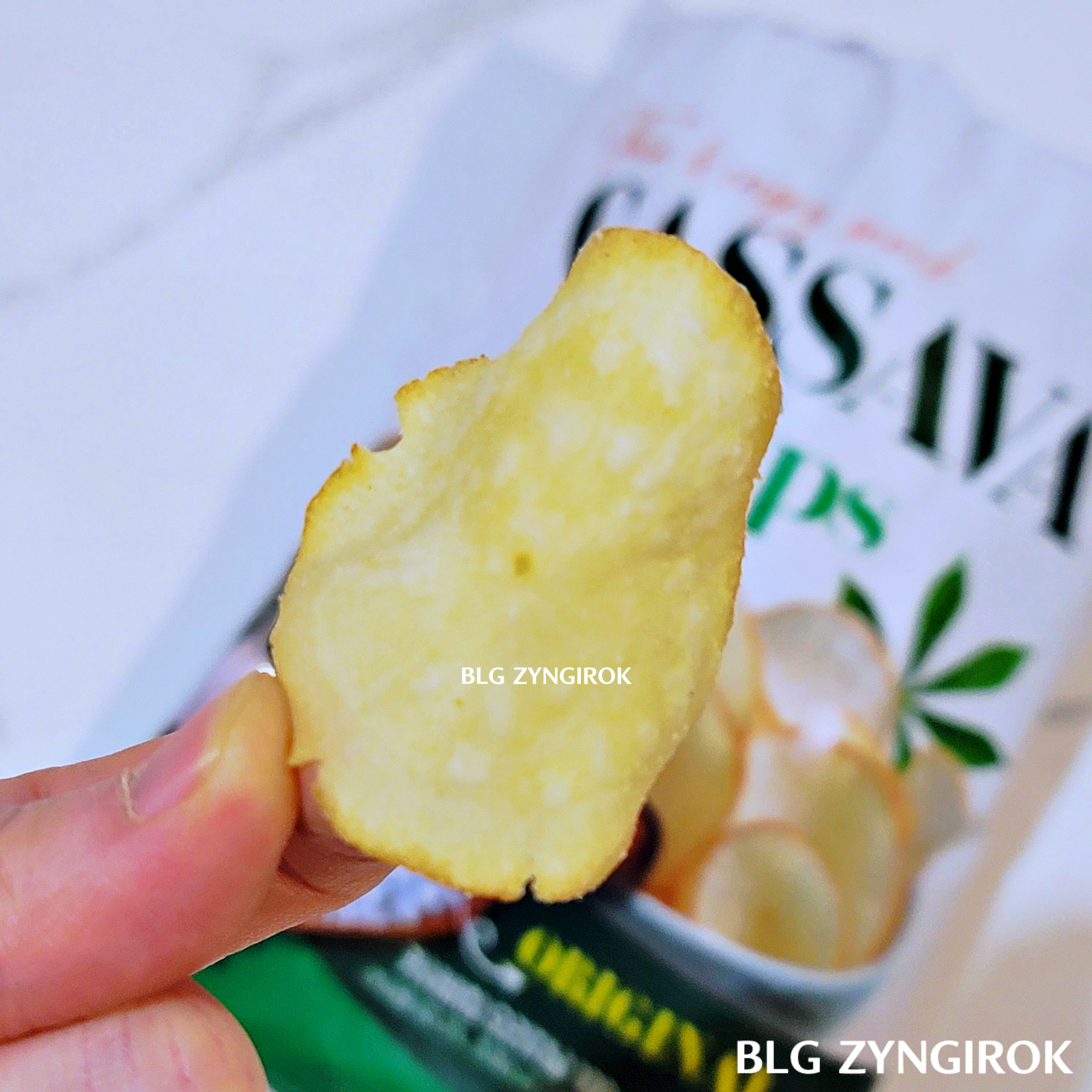 노브랜드 판매중인 카사바칩 - 카사바칩 오리지널 칩 한 개를 들고 있는 모습이다.