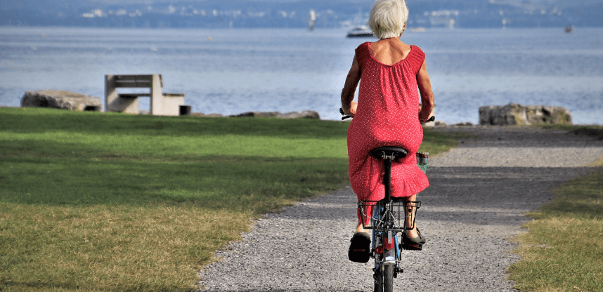 자전거를 타고 해변으로 가고 있는 노인 여자