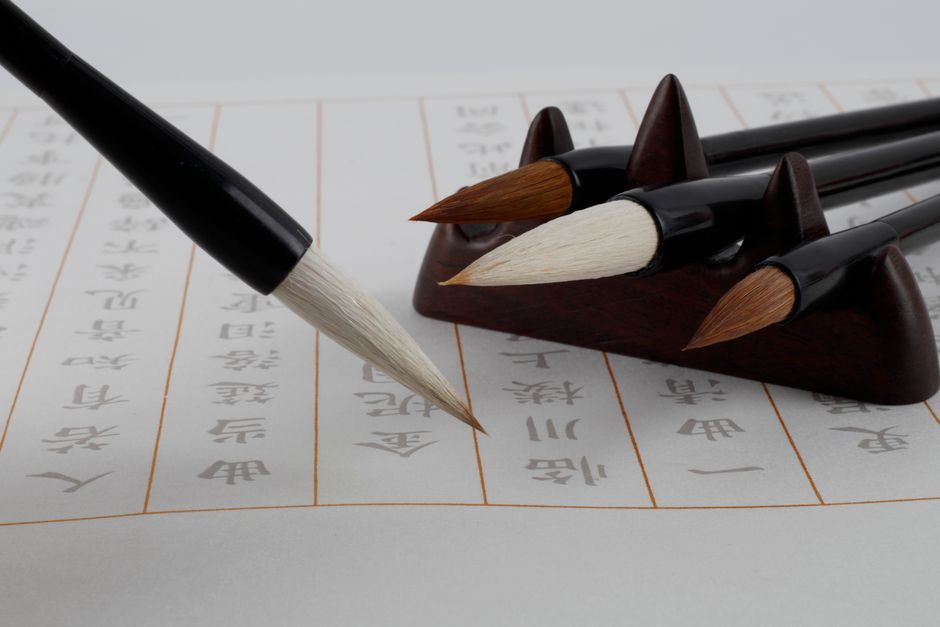 Set of Japanese calligraphy brushes with pointed tips and bamboo shafts on black holder