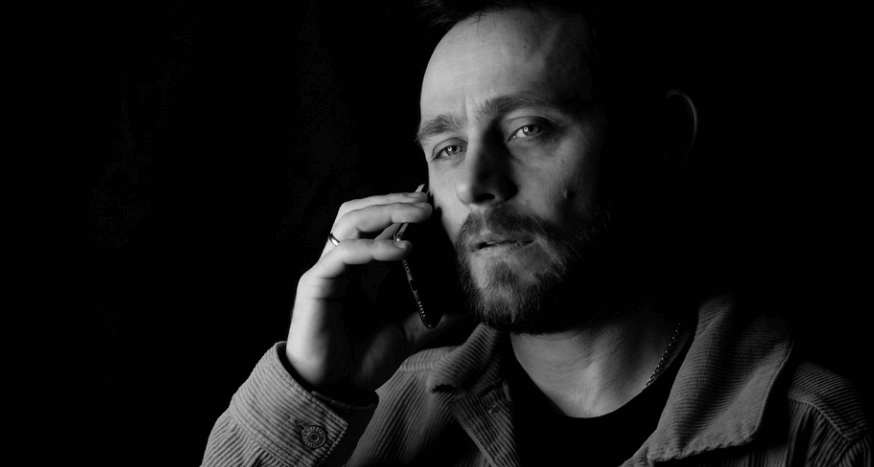 전화 통화를 하면서 피로를 느끼고 있는 남성