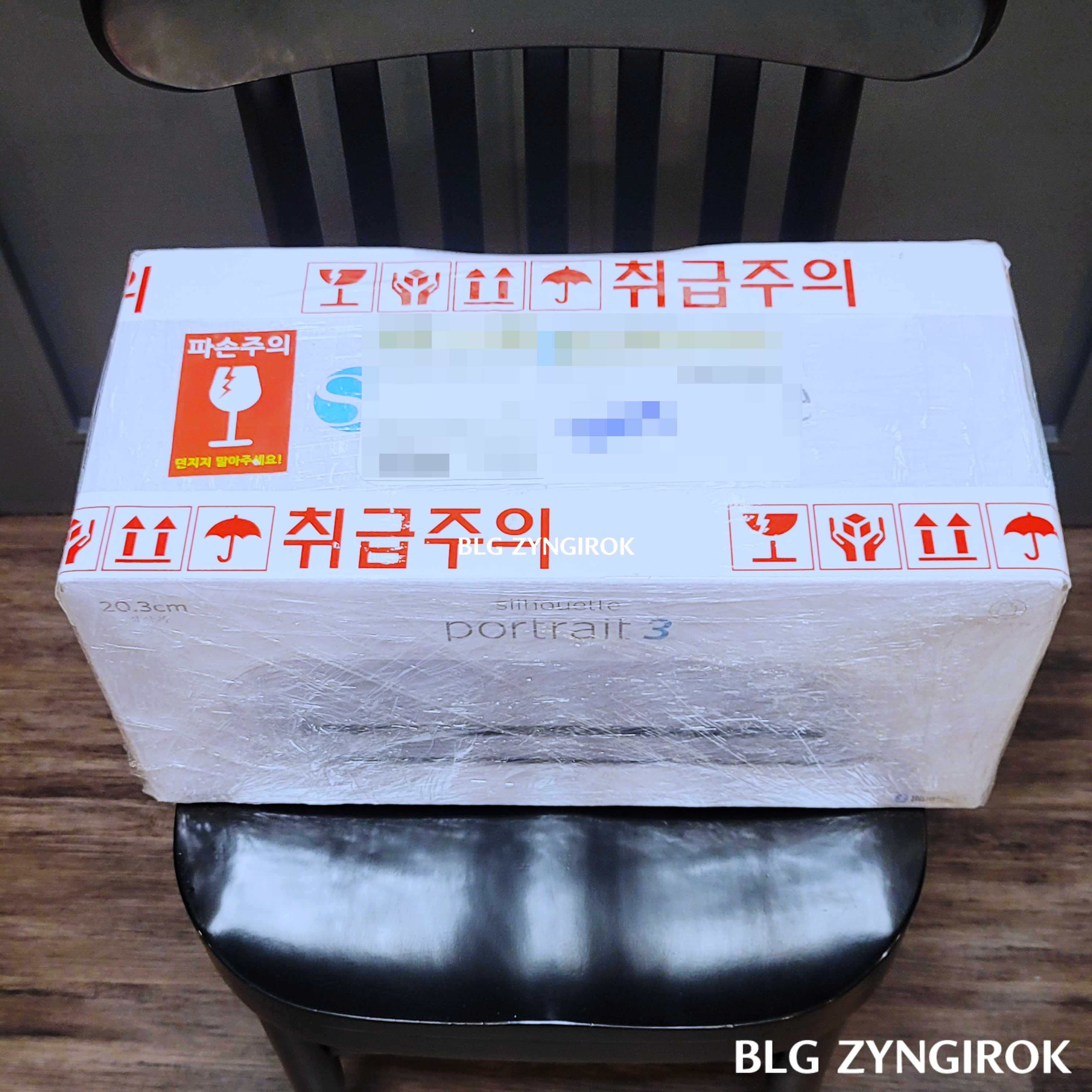 배송된-포트레이트3가-의자위에-놓여있다.