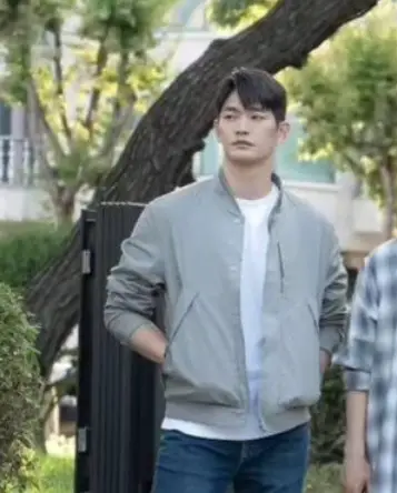 재벌X형사- 초록잎이 무성한 나무 앞 청바지에 회색 잠바 안 흰면티를 입고 앞을 바라보는 박준영