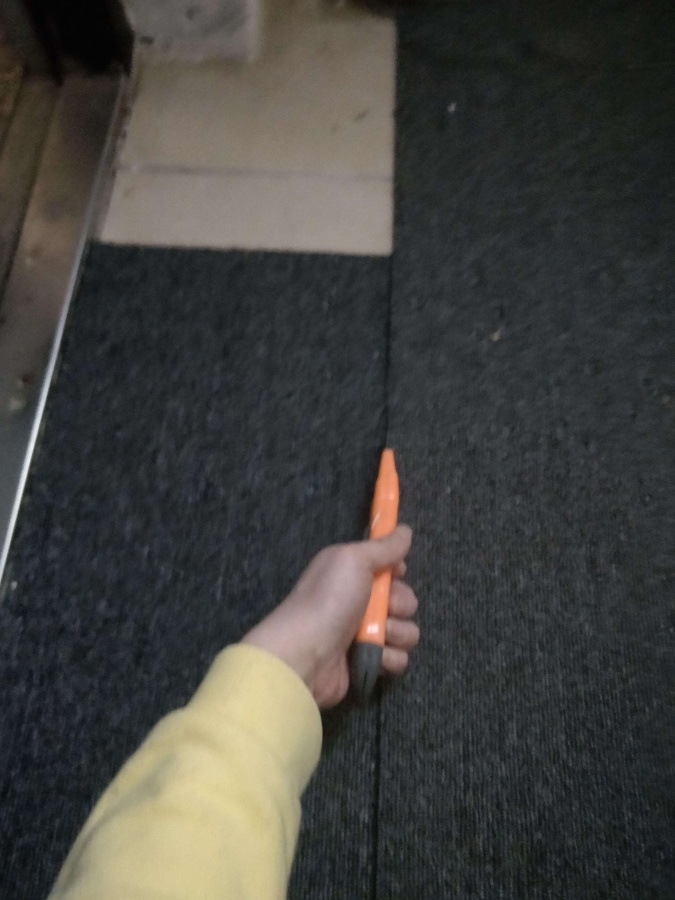 타일 카페트를 칼로 자르는사진