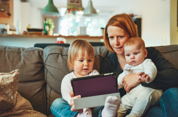 아기를 안고 태블릿으로 정보를 확인하는 부모 모습, 산모 신생아 지원 신청 상황