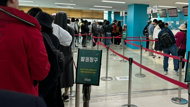 배를 타기 위해 발권 창구에서 줄을 선 사람들.