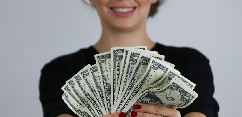 예쁜 여자가 돈을 펼쳐들고 기뻐하고 있는 사진