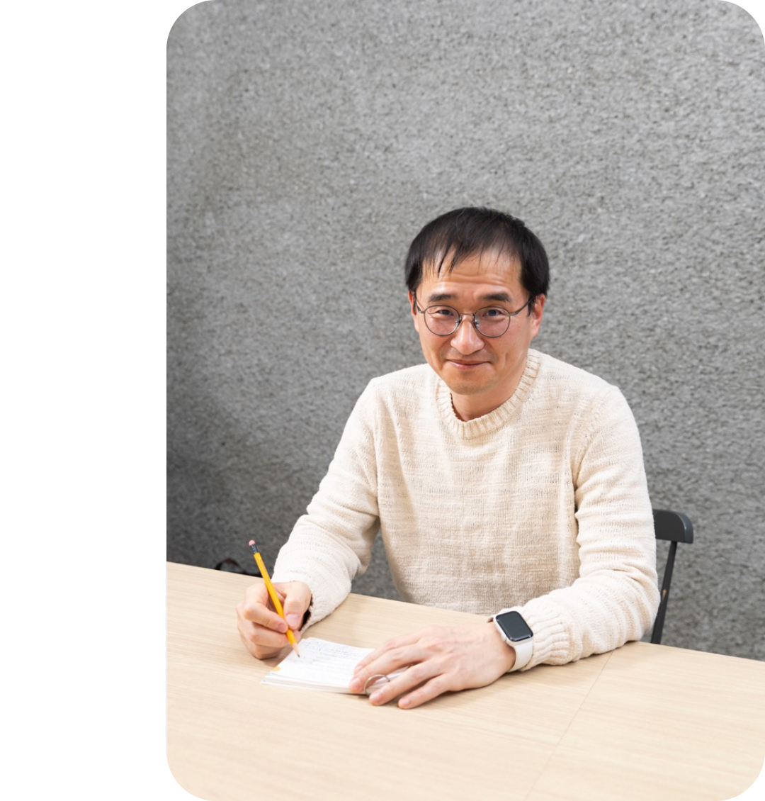 #펜을 든 채 카메라를 바라보고 있는 김연수 소설가