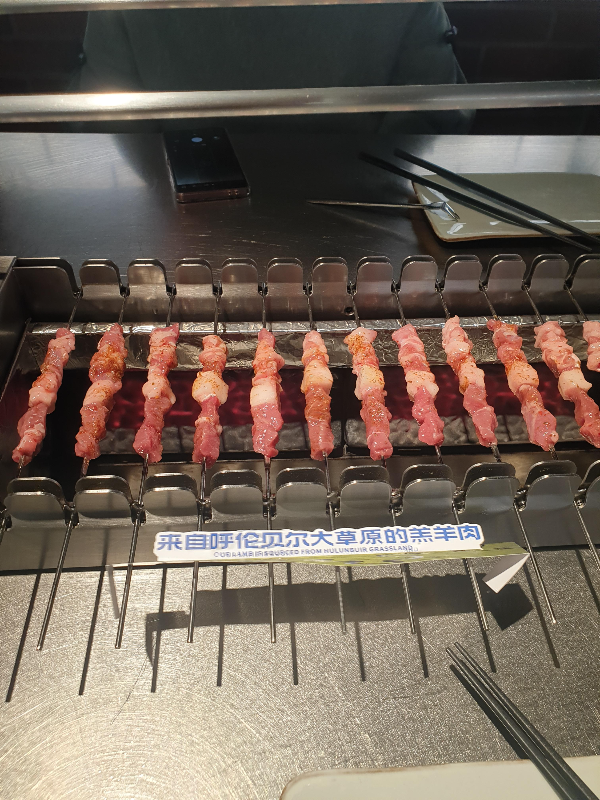 자동 양꼬치 그릴 위에 양꼬치들이 놓여 있는 모습