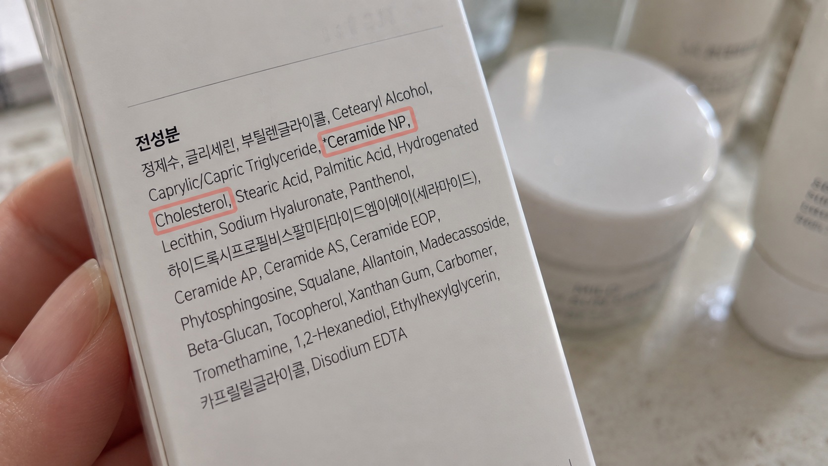 화장품 전성분표에서 콜레스테롤과 세라마이드 성분을 확인하는 모습