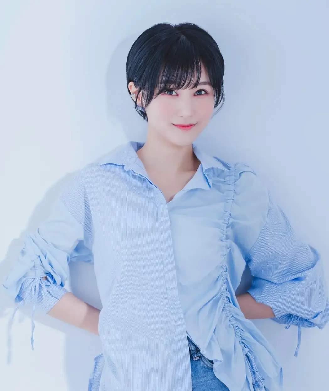 한일-파란벽 앞 파란색 셔츠를 입고 정면을 바라보고 서있는 마코토