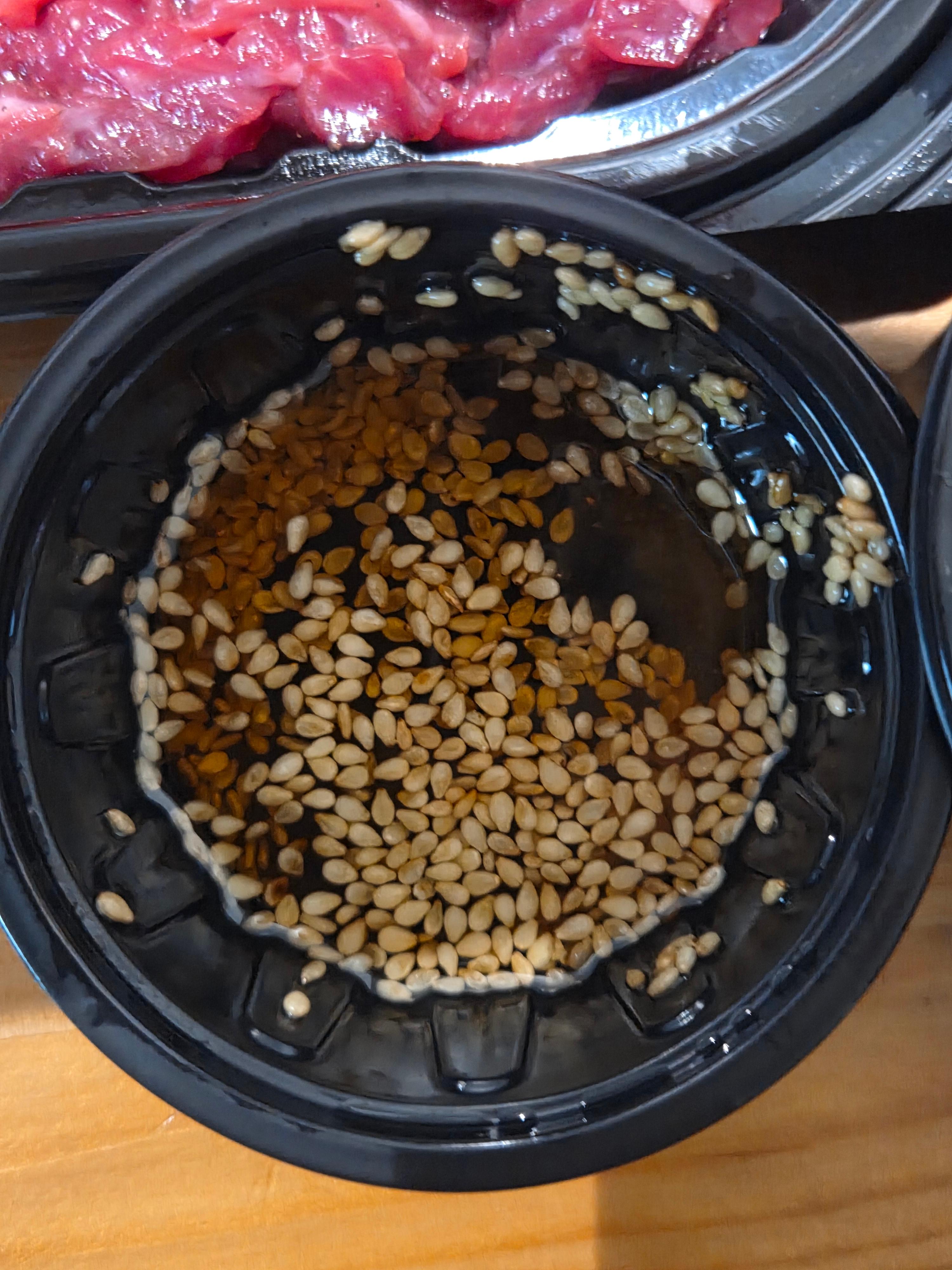 참깨가 듬뿍 뿌려진 소금 기름장 소스 용기