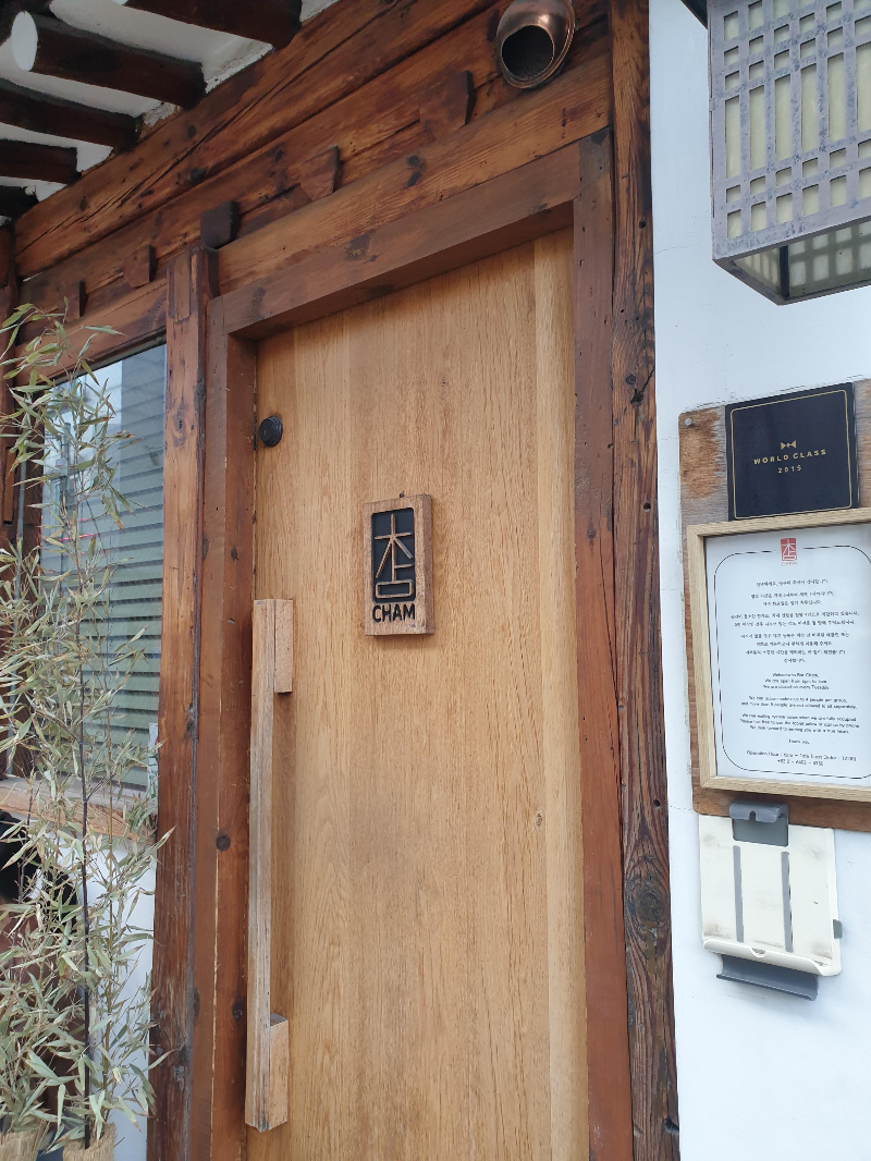 참이라고 쓰여인는 문패가 달린 나무문.