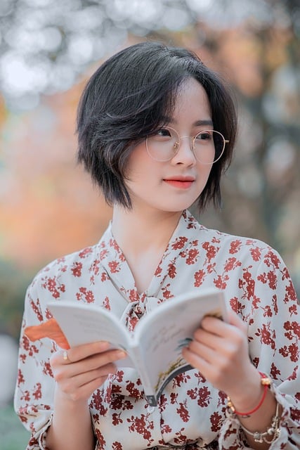단발머리의 여성이 책을 펼치고 있다