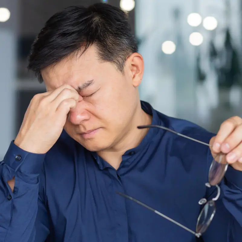 급성 녹내장 증상으로 심한 안구 통증과 두통을 느끼며 머리를 짚고 있는 사람의 모습