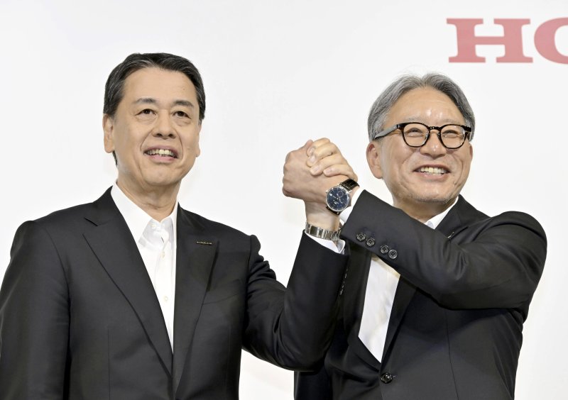 우치다 마코토일본 닛산자동차 사장(왼쪽)과 미베 도시히로 혼다 사장이 지난해 8월 1일 일본 도쿄에서 열린 공동 기자회견에서 악수하고 있다.