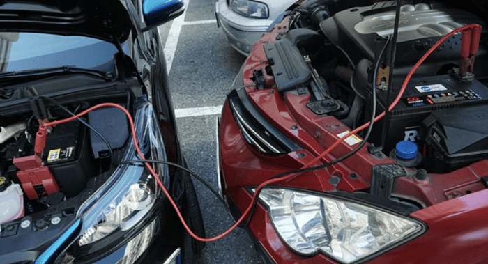 차량 밧데리 점프선 연결사진으로 왼쪽 검은색 차량에서 오른쪽 빨간색 차량으로 점프선이 연결된 사진