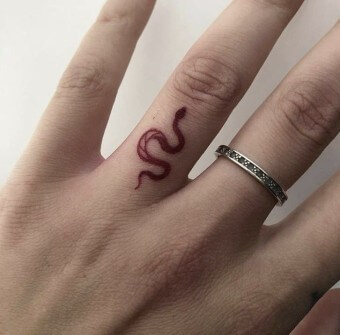 왼손-약지손가락-위에-뱀-타로-문신을-한-모습