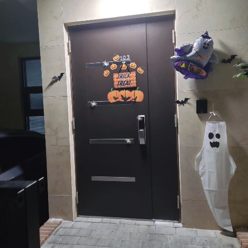 현관문 앞 할로윈 장식으로 유령, 호박, 박쥐 등으로 장식했고 가운데 trick or treat 라는 문구가 있다
