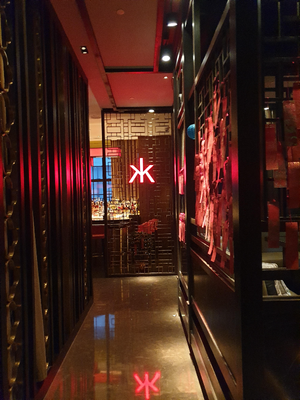 붉은색 간판이 보이는 입구. 전체적으로 어둡다.