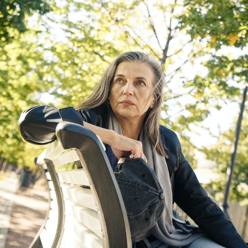 나이든-여성이-벤치에-앉아-어딘가를-보고-있는-장면