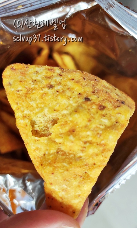 도리토스 나쵸치즈맛 과자 한 조각
