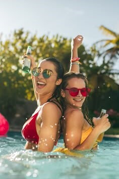 근육질의-여성-두명이-썬그라스를-끼고-물속에서-한손을-올리며-파이팅하는-모습