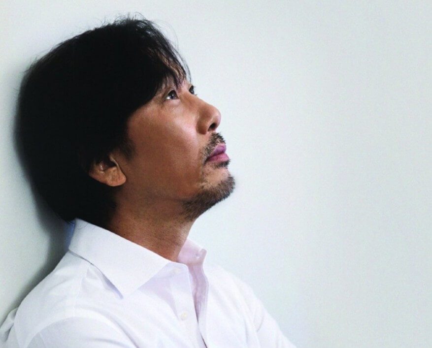 이문세가-하얀-셔츠를-입고-벽에-기댄-채-먼-곳을-응시하는-옆모습의-사진