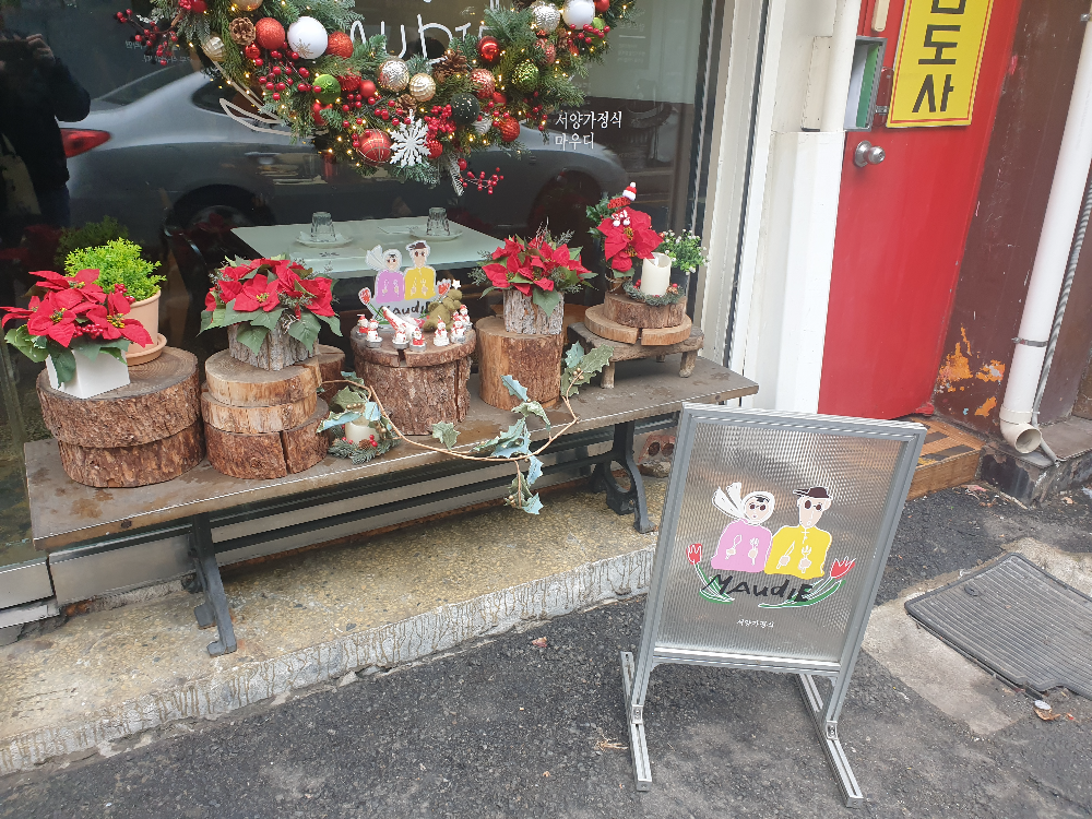 크리스마스 포인세티아로 꾸며져있는 외관 그 앞에 문제의 입간판이 놓여있다.