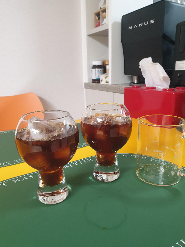 아이스커피를 완성한 모습. 테이블 위에 아이스커피 두 잔과 빈 서버가 올려져 있다.