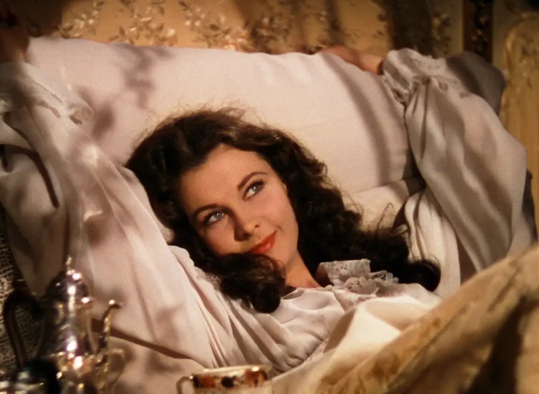 바람과 함께 사라지다의 주인공 스칼렛이 침대에 누워 웃고 있는 모습