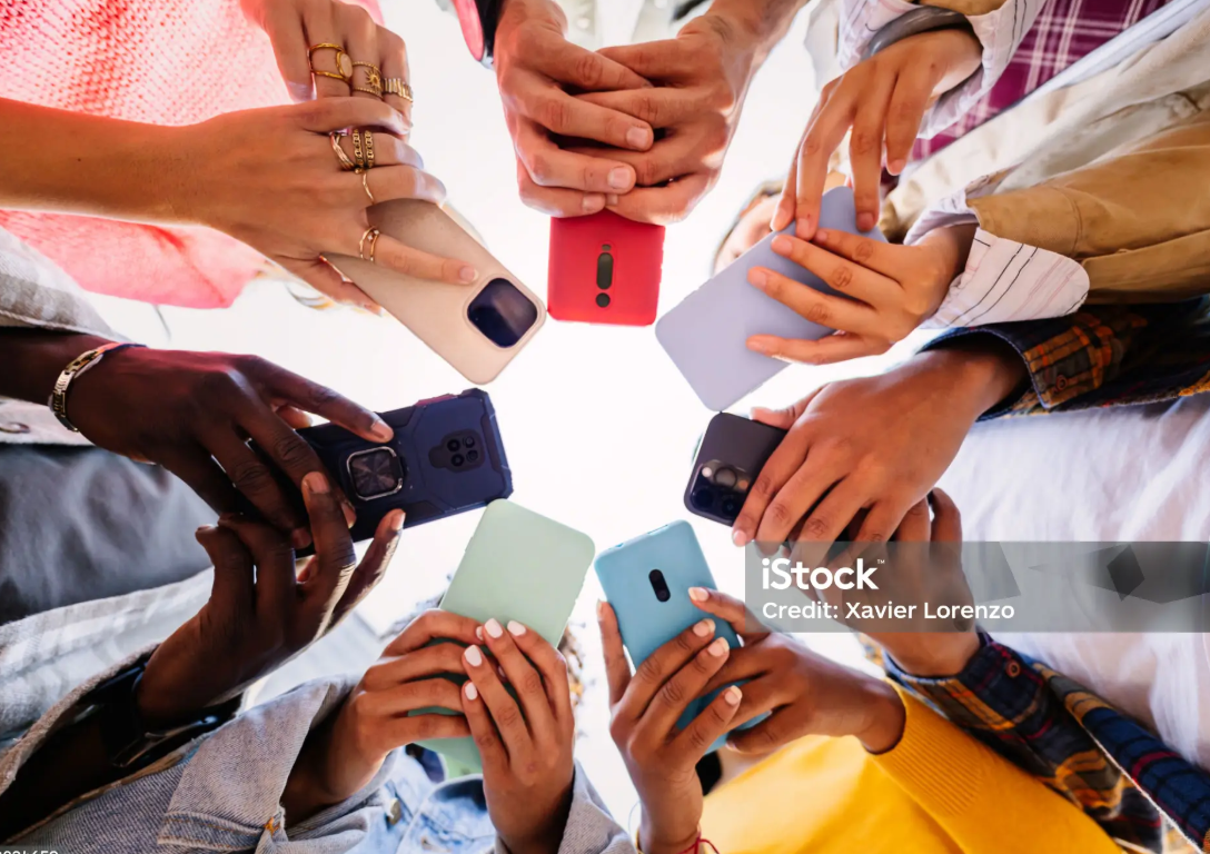 Young group of student people using smartphone together outside
