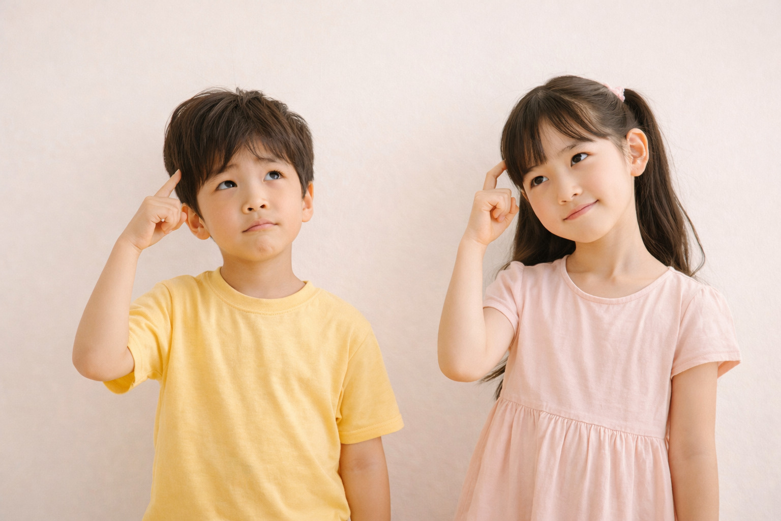 6살 남자아이와 9살 여자아이가 손가락을 머리에 대고 생각하는 듯한 제스처를 하고 있는 모습
