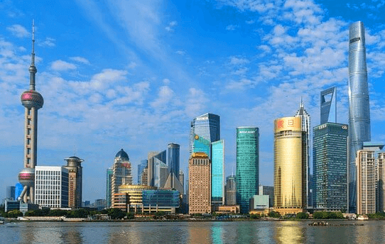 상하이 건물 풍경으로 아주 높은 건물들이 가득하고 앞에는 강물이 흐르고 있다.