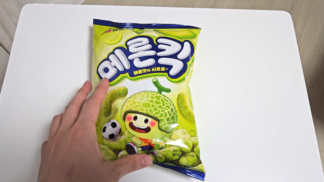 귀여운 캐릭터가 그려진 메론킥 과자 봉지 앞면 이미지