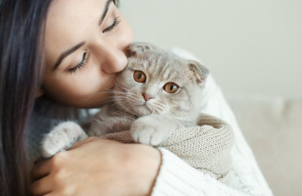 고양이를 안고 키스를 하는 여자.