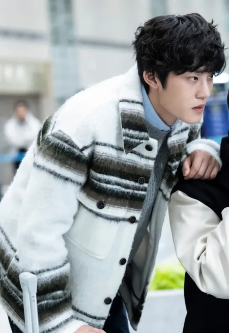 검은 곱슬머리에 휜 자켓을 입고 서 있는 드라마 7인의 탈출의 한청수 캐릭터