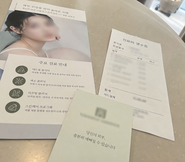 피부과 대기실 테이블 위에 놓인 주요 진료 안내 브로셔와 진료비 영수증 실제 사진