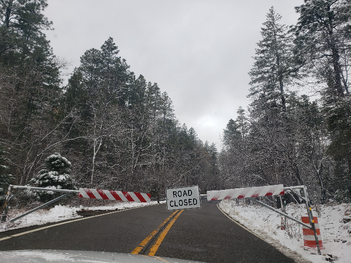 강한 눈보라 속에서 눈에 뒤덮인 스탑 사인, 애리조나 도로 폐쇄와 위험한 겨울 날씨를 상징함