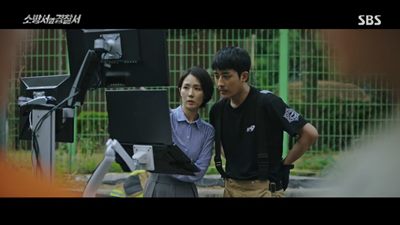 화재 원인을 조사하기 위하여 국가수 윤홍과 소방 봉도진이 함께 호흡을 맞추고 있는 장면입니다.