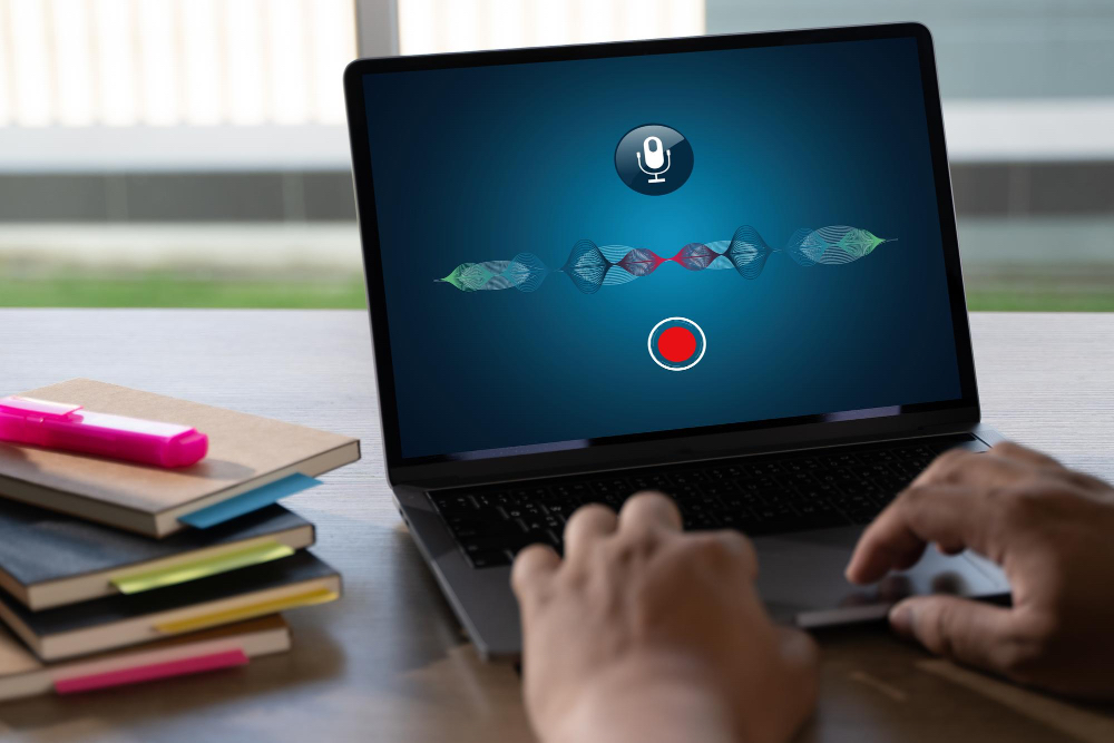 노트북에서 음성 입력 기능을 실행한 화면과 사용자의 손이 트랙패드를 조작하는 모습