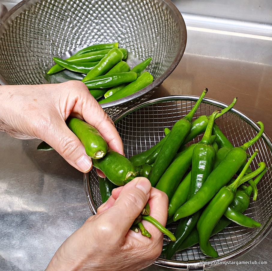 풋고추 된장무침에 들어갈 풋고추의 꼭지를 제거하는 사진