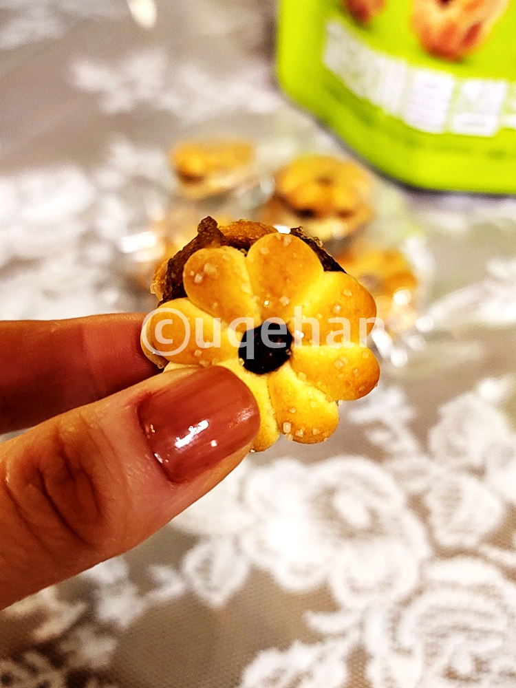 노브랜드 파인애플잼쿠키를 포장을 뜯어 손으로 집고 있다. 크기는 대략 500원짜리 동전 크기이다.