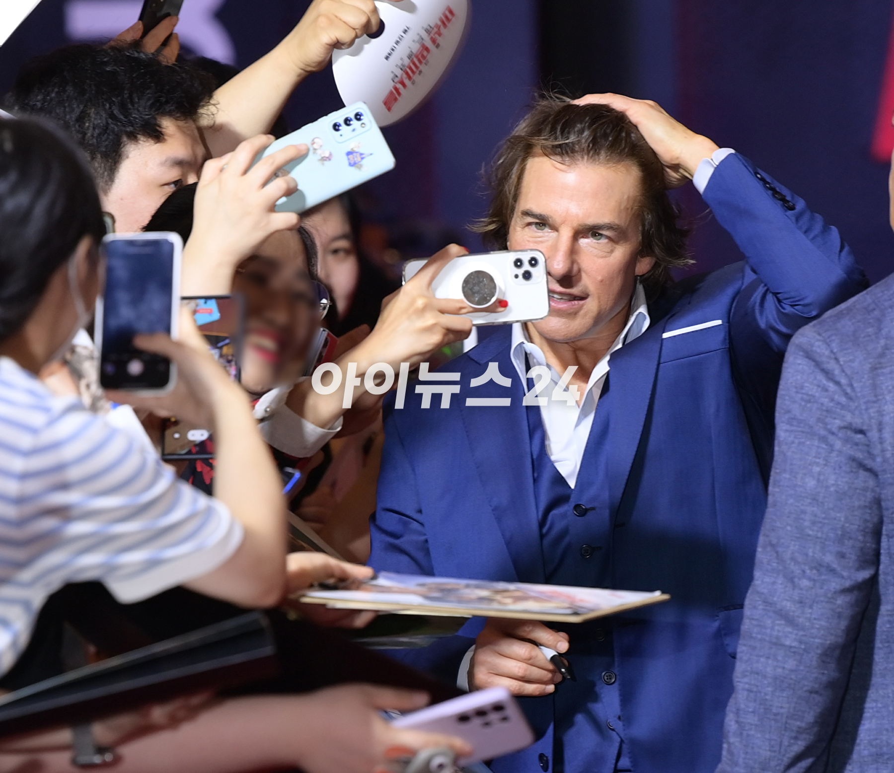 배우 톰 크루즈가 29일 오후 서울 송파구 롯데월드타워에서 진행된 영화 '미션 임파서블: 데드 레코닝 파트 원'(감독 크리스토퍼 맥쿼리) 내한 레드카펫 행사에 참석해 한 팬에게 자신의 얼굴이 새겨진 부채를 받고 기뻐하고 있다. [사진=정소희 기자]