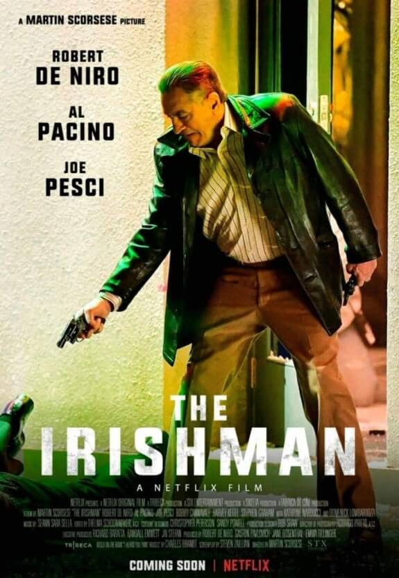 The Irishman 공식 포스터 : 주인공 프랭크 시런이 긴 가죽 재킷과 격렬한 표정으로 벽 앞에서 총을 든 장면