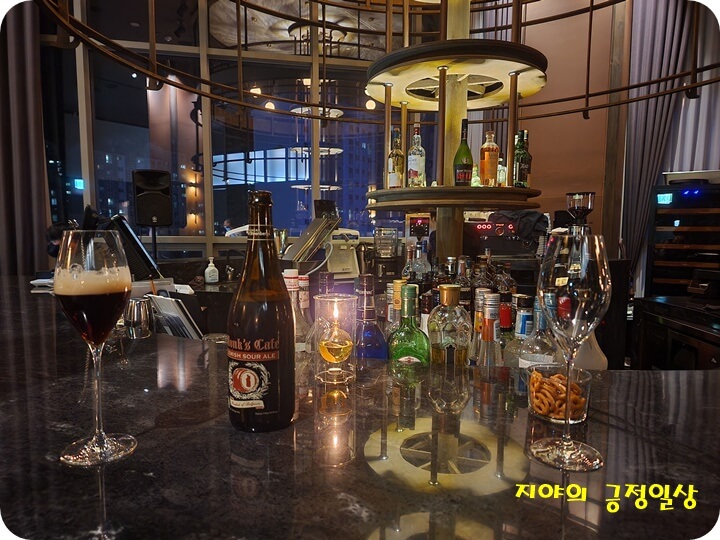 은은한 불빛의 홀 테이블위의 맥주와 선반에 있는 와인들