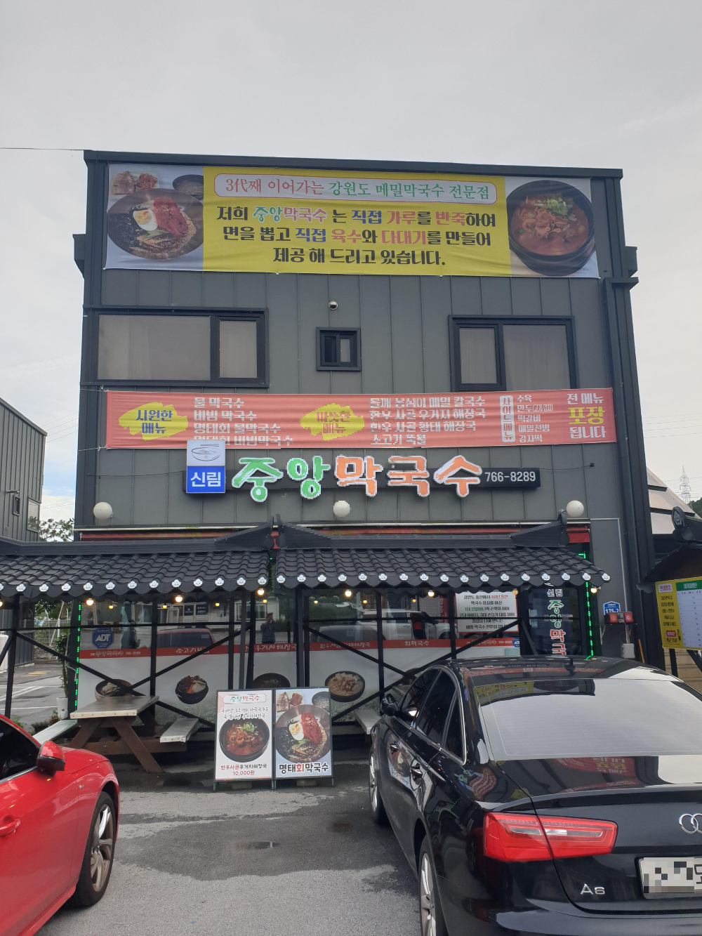 회색 판낼 2층 건물에 중앙막국수 가판이 보인다. 현수막으로 추가 홍보를 하고 있다.