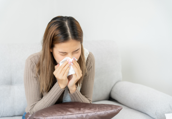 코를 풀고있는 여자의 모습.